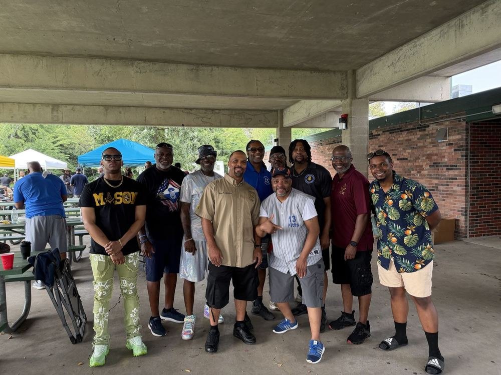 Ten brethren of the lodge gathered together in casual dress under a park pavilion at a lodge cookout.