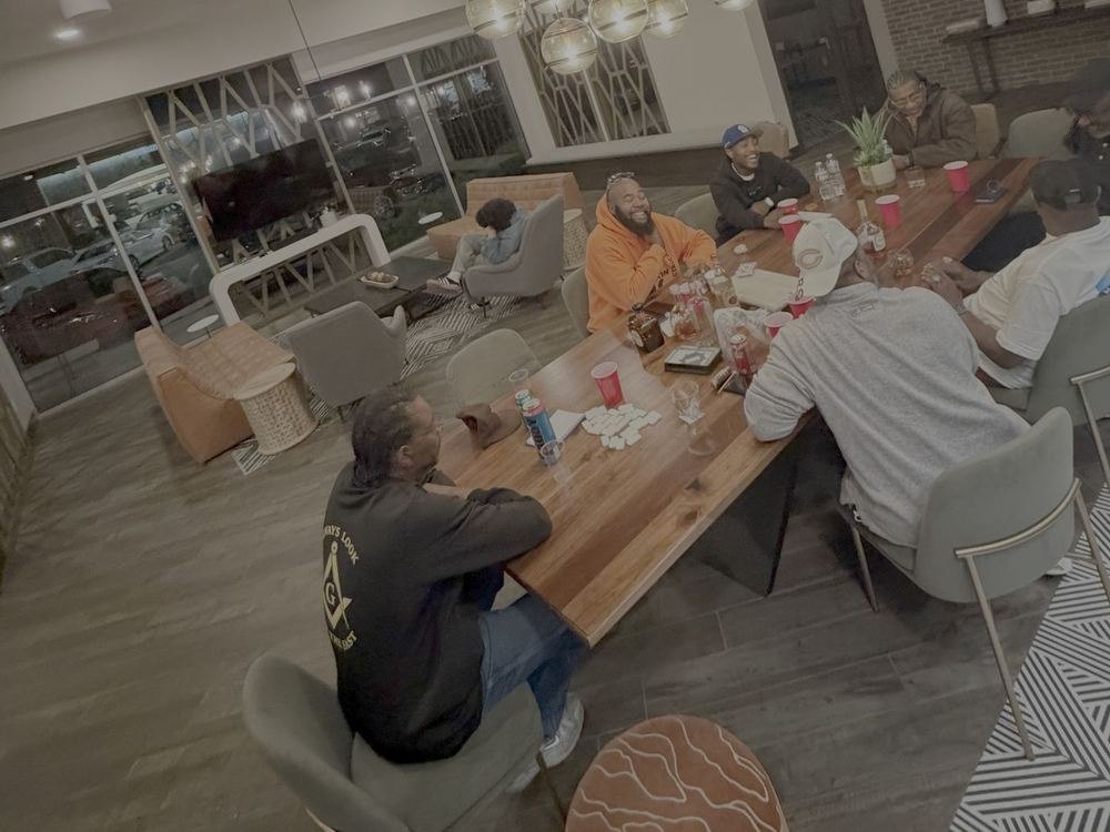 Brethren seated around a long table in the evening, talking and laughing together.