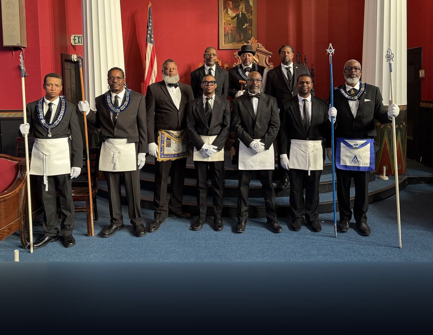 Nine brethren of Waterford Lodge No. 13 in formal dress with Masonic aprons, collars and jewels, standing together in the lodge room.